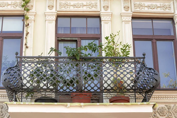 古老的乡村住宅阳台 有一个锻造的弧形铁栏杆 墙上有盆栽 墙上有一个漂亮的大窗户 — 图库照片