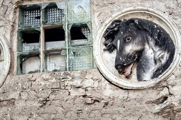 Siyah atlar eski heykelleri yıpranmış tuğladan duvarın kırık, kalın bir penceresinin yanında yaparlar.