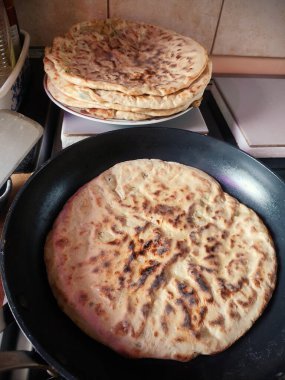 Soğanlı, peynirli ve patatesli, tavada pişmiş, fırının tepesinde altın renginde ve cızırtılı