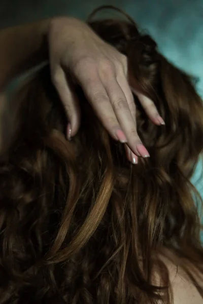 美丽的女性手部的特写 带有简单的指甲修剪 灰色背景 选择性聚焦 长长的手指和脆弱的手腕 黑色长长的红头发背景下的塑料动作 — 图库照片
