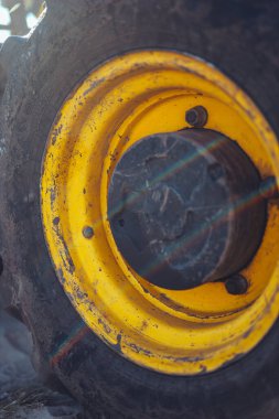 Büyük sarı bir traktörün parçası, yakın çekim, tüp ve bağlantı detayları. Parlak güneş ışığı, güzel teknik arkaplan