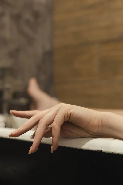 Mooie Vrouwelijke Handpalm Met Natuurlijke Manicure Voorgrond Benen Bad Ontspannen — Stockfoto