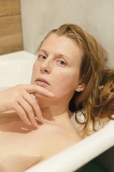 快乐的女士躺在浴缸里 享受着家庭温泉的美感 自由自在的空间 漂亮的女人在热水澡里放松 家居美容治疗 漂亮的背景 有选择的焦点 — 图库照片