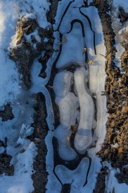 Suyun üzerindeki buzlu buzlar. Buz, buz sarkıtları ve kalıpların oluştuğu Soğuk Nehir. Güneşli bir gün, parlıyor, parlıyor. Güzel doğal arkaplan, doğal doku.