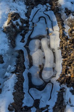 Suyun üzerindeki buzlu buzlar. Buz, buz sarkıtları ve kalıpların oluştuğu Soğuk Nehir. Güneşli bir gün, parlıyor, parlıyor. Güzel doğal arkaplan, doğal doku.