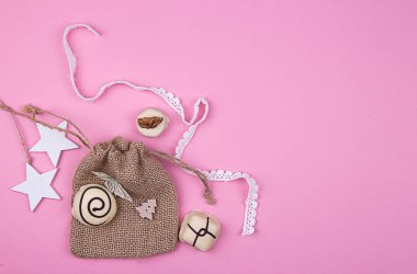 Yılbaşı süslemeleri. Tebrik kartı. Beyaz çikolata, pembe arka planda hediye paketi. Üst Manzara. Düz yatıyordu.