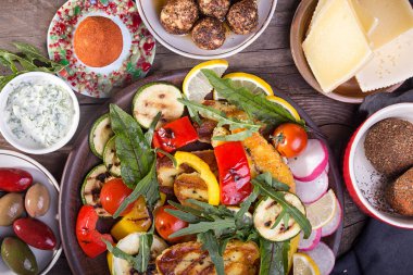 Peynir ve abur cubur seti. Eski ahşap arka planda ızgara halloumi, belper knolle, zeytin, tzatziki sosu. Genel giderler. 