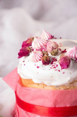 Tebrik kartı için mutlu Paskalya süsleri. Beyaz kremalı Paskalya pastası, marşmelov, kuru gül çiçekleri ve gül rengi el işi kağıtları. Klasik stil.