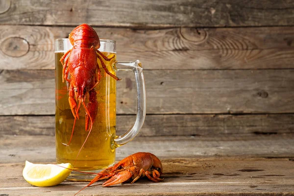 Beer party. Still life with glass of beer, crayfish crawfish against old wooden rustic background. Front view.