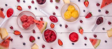 Buzlu meyve ve böğürtlen şerbeti topla. Çeşitli karpuz, dut, ahududu, yabanmersini, çilek, ahşap beyaz arka planda kavun şerbeti. en üstteki görünüm. 