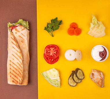 Popüler Arap Türklerinin fast food bağışçısı shawarma rolleri, modaya uygun arka planda et ve sebzelerle. Geometrik Düzen İçindekiler bileşimi. Üst Manzara. Düz yatıyordu