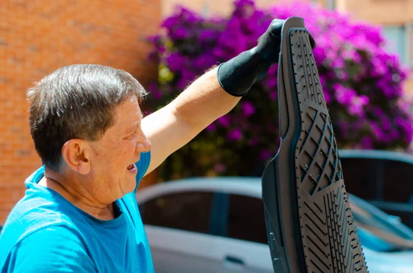 Mature man washing car mats