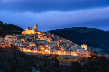 The beautiful village of Castel del Monte illuminated in the evening, in the Province of L'Aquila, Abruzzo, central Italy. clipart