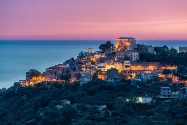 stock image Panoramic view of Castellabate illuminated in the evening with the sea in the background. Cilento, Campania, southern Italy.