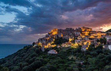 Panoramic view of Pisciotta illuminated in the evening with the sea in the background. Cilento, Campania, southern Italy. clipart