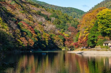 Sonbahar mevsiminde ünlü Arashiyama ormanındaki Katsura nehri boyunca güzel bir manzara. Kyoto, Japonya.