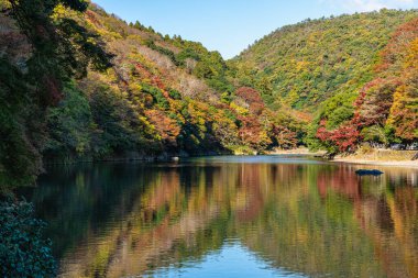 Sonbahar mevsiminde ünlü Arashiyama ormanındaki Katsura nehri boyunca güzel bir manzara. Kyoto, Japonya.