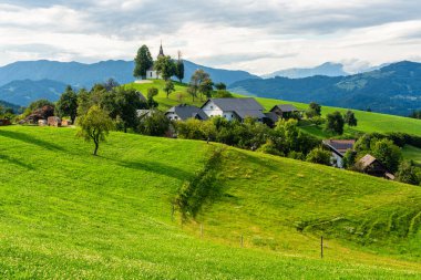 Slovenya 'daki Skofia Loka yakınlarındaki Saint Thomas Kilisesi' nin yanında İdilik yaz öğleden sonrası manzarası.