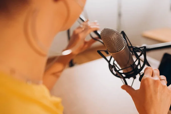 a woman speaks into a microphone. Talking in the microphone in online broadcasts.