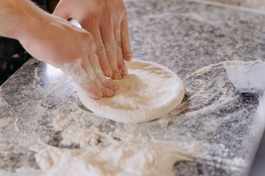 male hands making dough for pizza bread or pastries