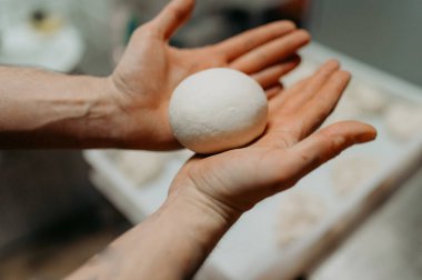 bir kesme tahtası üzerinde ekmek hamur yoğurma eller