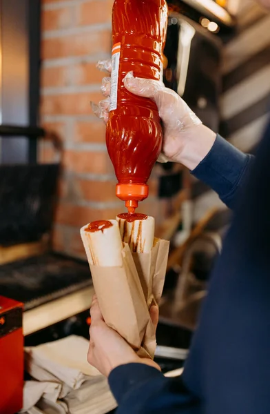 Man Prepares French Hot Dog Pours Sauce — Foto de Stock