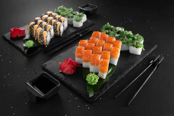 Conjunto Sushi Rollos Con Pescado Conjunto Papeles Sobre Fondo Negro —  Fotos de Stock