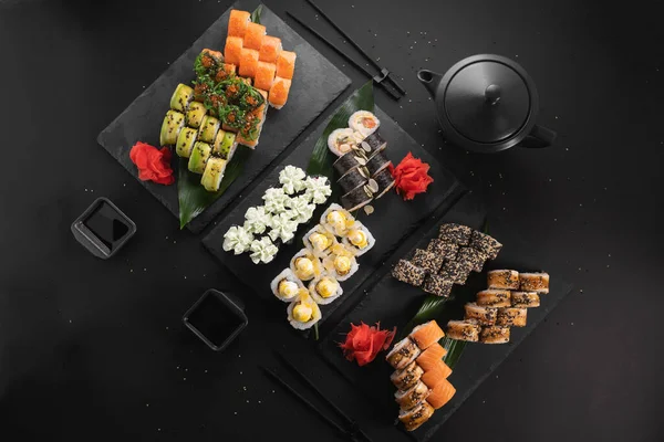 Siyah arkaplanda suşi var.
