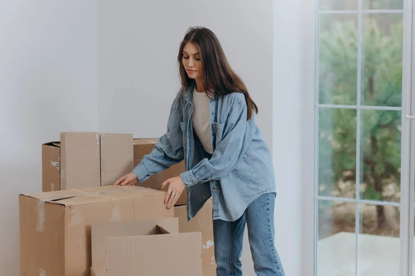 A woman packs her belongings in boxes to move to a new apartment. moving to a house.