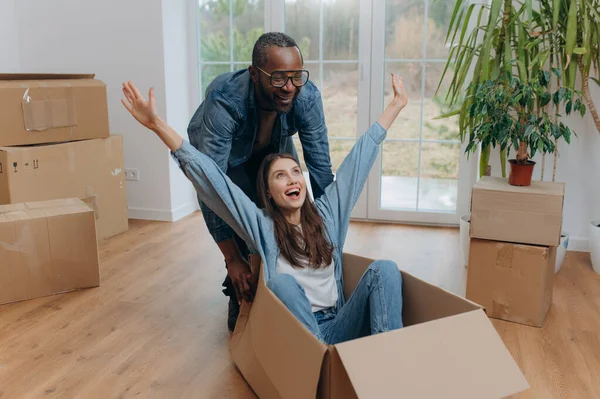 Taşınma gününde bavullarını açıp gülen mutlu bir ırk çifti. Karton bir kutuda seyahat eden mutlu bir kadın. Afro-Amerikalı bir adam karton bir kutunun içinde bir kadına biniyor.