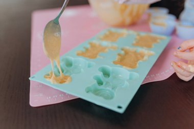 Kurabiye yapmak için silikon kalıplara çiğ hamur dök. Pişirme hazırlığı süreci.