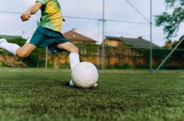 Küçük bir futbolcu kalede topa vuruyor. Çocuk Futbol Oynuyor