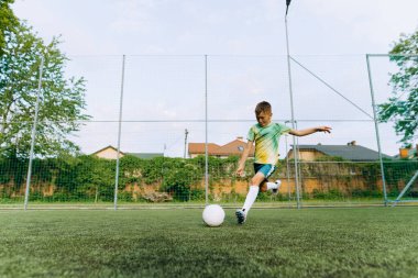 Küçük bir futbolcu kalede topa vuruyor. Çocuk Futbol Oynuyor