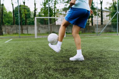 Kız futbolcu futbol sahasında topla birlikte çalışıyor. Antrenmanda futbolcu