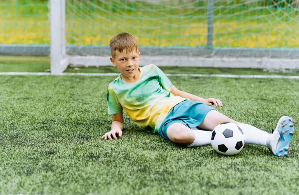 Futbol sahasında formalı bir çocuk futbolcu.