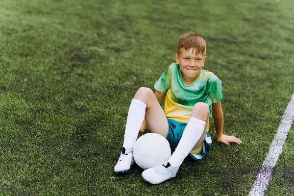 Futbol sahasında formalı bir çocuk futbolcu.