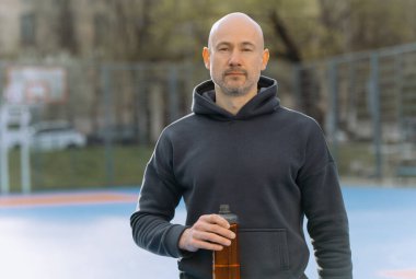 Başarılı bir sporcu dinlenir ve gülümser, antrenmanın sonucuna sevinir.