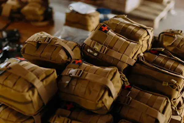 A group of military first aid kits on a table. Tactical first aid kits for the military. first aid kit camouflage