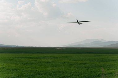 Mavi gökyüzünde uçan bir dron. Bulutların üzerinde uçan insansız hava aracı, teknoloji. Kavram: Askeri keşif aracı, gökyüzünde olay, Ukrayna 'da savaş.