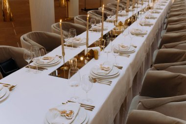 Düğün masasında kristal şarap kadehleri, altın çatallar ve bıçaklar var. Yemek ziyafeti. Kutlama yıldönümü için masa dekorasyonu, Noel, yeni yıl. Settin Grestaurant 'ın masası. seçici odak