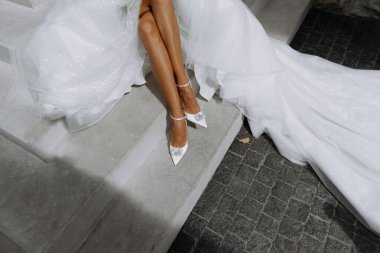 Wedding white shoes on the bride's feet. Close-up. feet of the bride at the wedding. shoes, dress, top view clipart