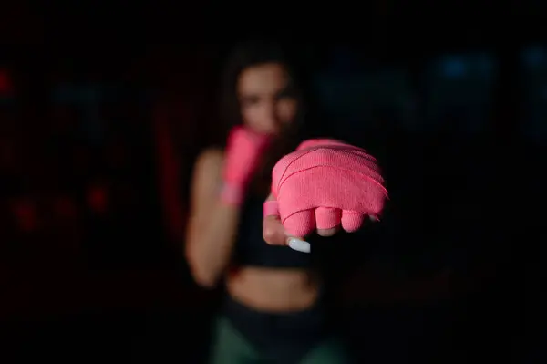 Yakın plan, kadın boksör yumruğu, dövüş sanatları atleti. Boks için pembe bandajlı kadın boksör. Kadınlar boksu.