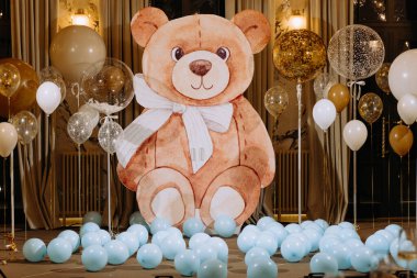 Çocuğun vaftiz töreni için fotoğraf bölgesi mavi taşaklarla süslenmiş. Restoranda vaftiz.