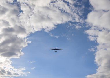 Mavi gökyüzünde uçan bir dron. Bulutların üzerinde uçan insansız hava aracı, teknoloji. Kavram: Askeri keşif aracı, gökyüzünde olay, Ukrayna 'da savaş.