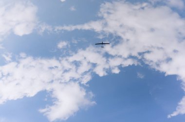 Bir dron havada süzülüyor, dağınık bulutların arasında havadan görüntüler yakalıyor. Bu uzaktan kumandalı uçak, gelişmiş teknolojiler kullanarak etkili bir şekilde çalışıyor..