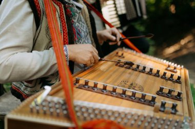 Bir müzisyen geleneksel bir telli çalgıyla doğal bir ortamda şarkı söyler. Canlı giysiler büyüleyici bir melodi yaratırken kültürü ön plana çıkarıyor.