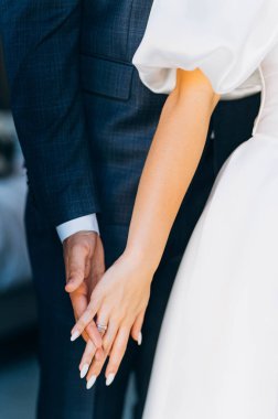 Partnerler arasındaki romantik an sevgi ve bağlılık göstergesidir. Eller birbirine dolanmış, yüzük özel bir durum sırasında aşkı simgeliyor..