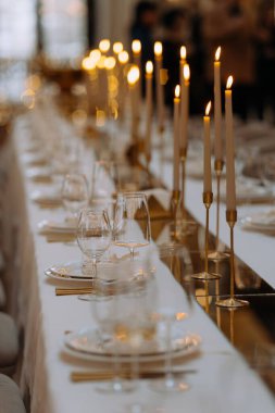 Yanıp sönen mumlar ve cilalanmış camlarla dolu davetkâr bir akşam yemeği. Uzun masa özel bir durum için hazırlandı. Güzel tabaklar ve çatal bıçak takımı zarif bir şekilde yerleştirildi..