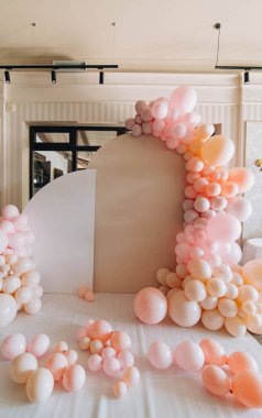 Pembe ve şeftali rengi balonlardan oluşan canlı bir düzenleme tuhaf bir zemin oluşturur. Çeşitli boyut ve gölgeler zarif bir mekanda göze çarpan bir odak noktası oluşturur..