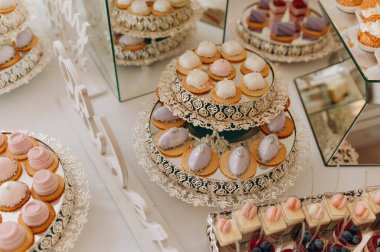 Hassas şekerlemeler, katlı tribünlere güzelce yerleştirilmiş. Çeşitli rengarenk şeyler konukları tatlı bir deneyime davet eder..